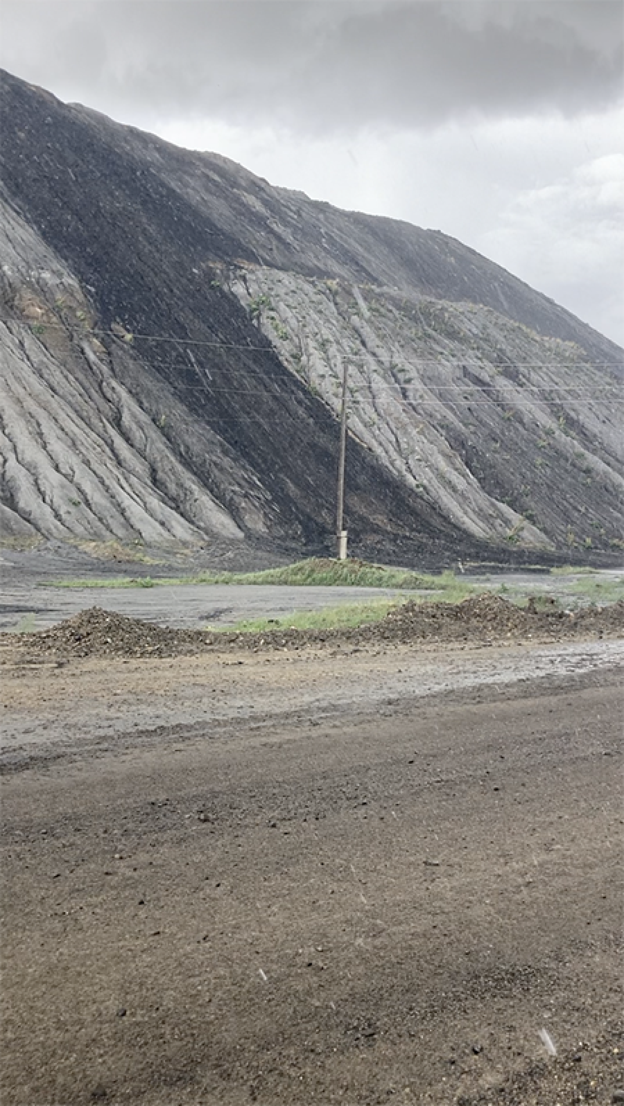 Figure 1: The vast mounds of tailings left over by the open cut mining, put into perspective by the powerlines. Photo: Emilie Barrelle